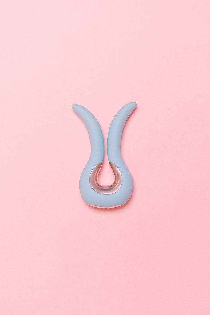 Stylish silicone sex toy displayed on a pastel pink background, emphasizing modern design.